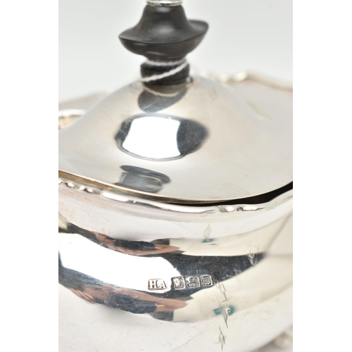 149 - A GEORGE V SILVER TEA CADDY OF OVAL FORM, the hinged cover fitted with an ebony finial, on four paw ... 