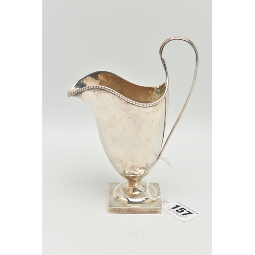 157 - AN EDWARDIAN BRITANNIA STANDARD SILVER HELMET SHAPED CREAM JUG, beaded rim, strap handle, short pede... 