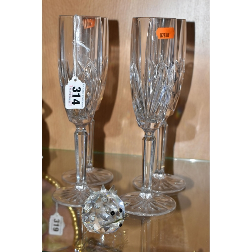 314 - FOUR MARQUIS BY WATERFORD CHAMPAGNE FLUTES AND A SWAROVSKI CRYSTAL HEDGEHOG, the Waterford glasses i... 