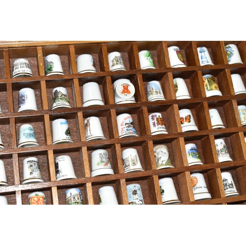 519 - A LARGE COLLECTION OF PORCELAIN THIMBLES, to include fourteen wooden thimble display stands and over... 