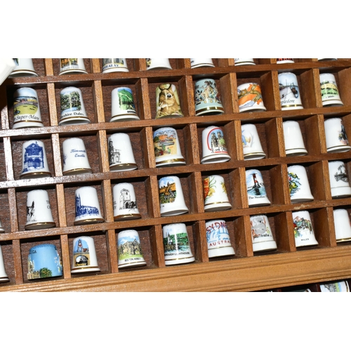 519 - A LARGE COLLECTION OF PORCELAIN THIMBLES, to include fourteen wooden thimble display stands and over... 