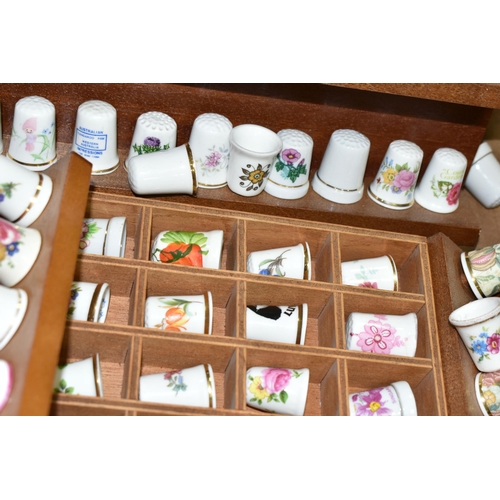 519 - A LARGE COLLECTION OF PORCELAIN THIMBLES, to include fourteen wooden thimble display stands and over... 