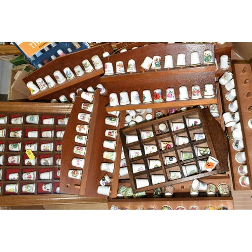 519 - A LARGE COLLECTION OF PORCELAIN THIMBLES, to include fourteen wooden thimble display stands and over... 