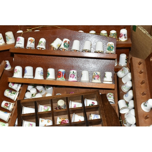 519 - A LARGE COLLECTION OF PORCELAIN THIMBLES, to include fourteen wooden thimble display stands and over... 