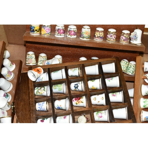 519 - A LARGE COLLECTION OF PORCELAIN THIMBLES, to include fourteen wooden thimble display stands and over... 