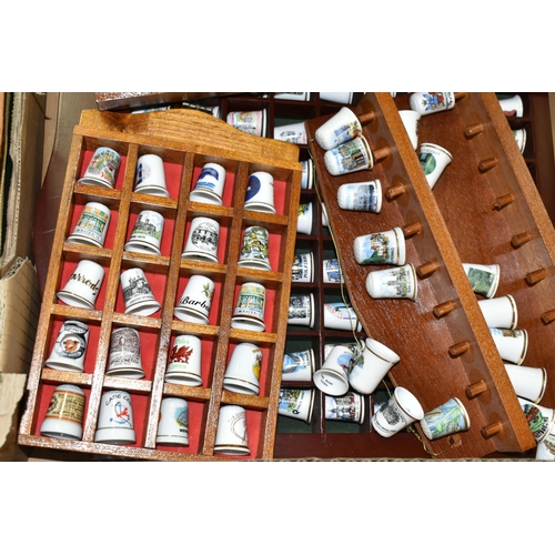 519 - A LARGE COLLECTION OF PORCELAIN THIMBLES, to include fourteen wooden thimble display stands and over... 