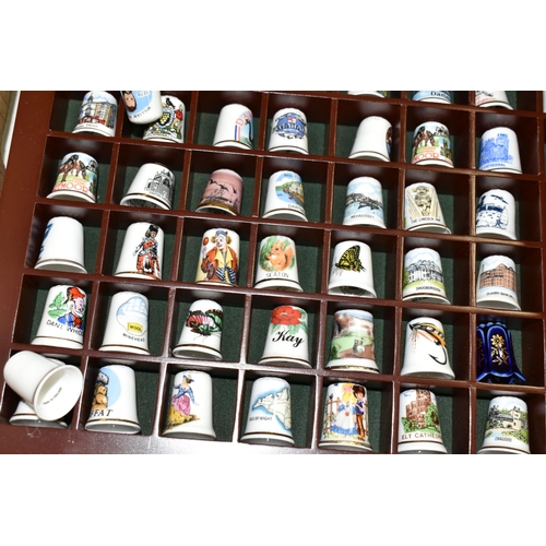 519 - A LARGE COLLECTION OF PORCELAIN THIMBLES, to include fourteen wooden thimble display stands and over... 