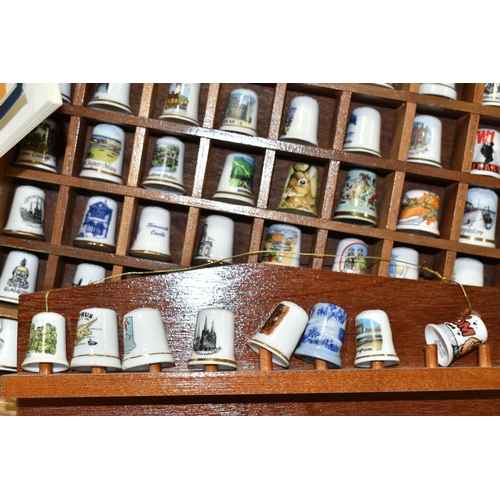 519 - A LARGE COLLECTION OF PORCELAIN THIMBLES, to include fourteen wooden thimble display stands and over... 