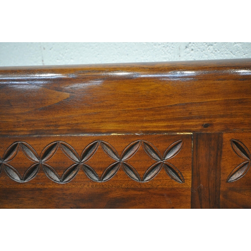 1211 - AN ANGLO INDIAN COLONIAL STYLE HARDWOOD CHILDS BENCH, carved with geometric designs, scrolled armres... 