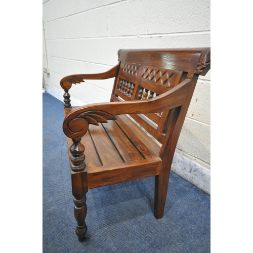 1211 - AN ANGLO INDIAN COLONIAL STYLE HARDWOOD CHILDS BENCH, carved with geometric designs, scrolled armres... 