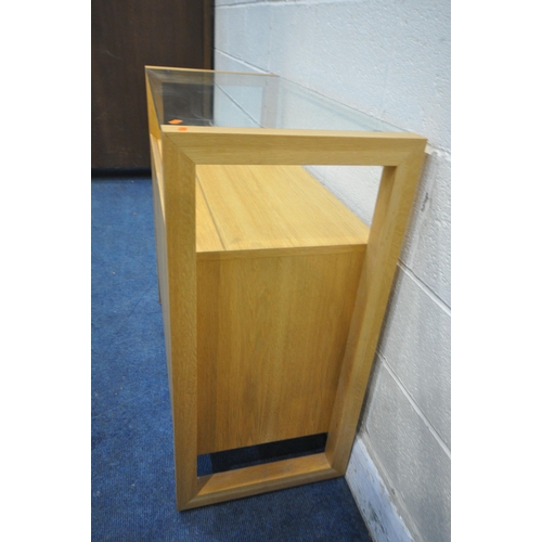 1224 - A SOLID LIGHT OAK SIDE TABLE, with a glass top, above two cupboard doors, width 90cm x depth 42cm x ... 