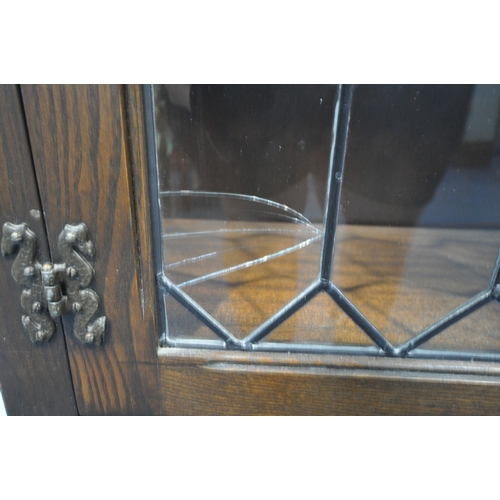 1230 - A 20TH CENTURY OAK JAYCEE BOOKCASE, with double lead glazed doors above double linenfold doors, widt... 