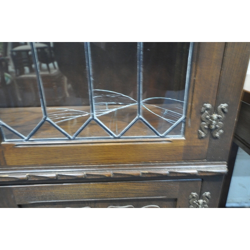 1230 - A 20TH CENTURY OAK JAYCEE BOOKCASE, with double lead glazed doors above double linenfold doors, widt... 