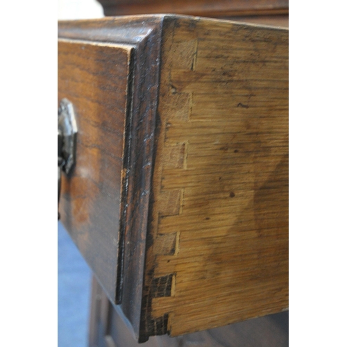 1236 - A 20TH CENTURY OAK MIRROR BACK SIDEBOARD, with an arched bevelled mirror plate, flanked by twin turn... 