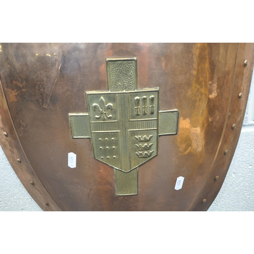 1248 - A DECORATIVE HANGING COPPER SHIELD, with brass trim and coat of arms, cross swords to rear, width 41... 