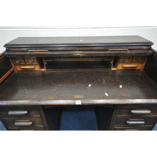 1253 - A 20TH CENTURY OAK ROLL TOP DESK, with a fitted interior, with an arrangement of nine drawers and tw... 