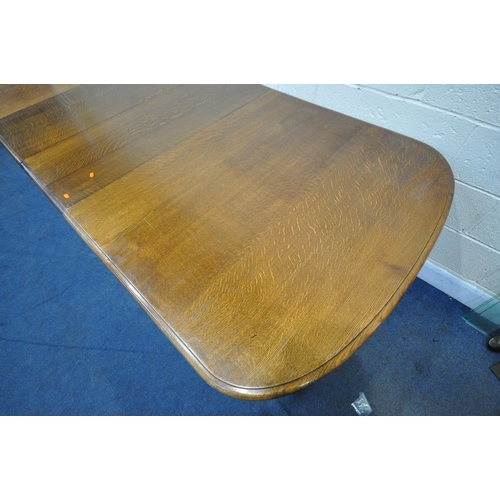 1321 - A LATE 19TH / EARLY 20TH CENTURY OAK WIND OUT DINING TABLE, with rounded ends, two additional leaves... 