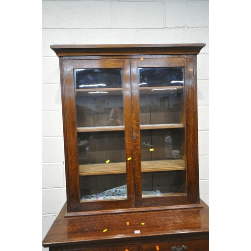 1325 - A 20TH CENTURY OAK BOOKCASE, the double glazed doors enclosing three shelves, above two drawers and ... 