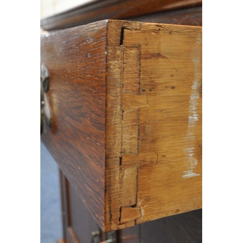 1325 - A 20TH CENTURY OAK BOOKCASE, the double glazed doors enclosing three shelves, above two drawers and ... 