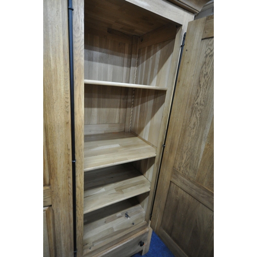 1329 - A LARGE GOOD QUALITY LIGHT OAK TRIPLE DOOR WARDROBE, with a fixed cornice, an arrangement of interna... 