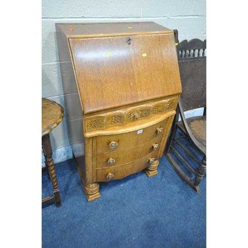 1331 - A 20TH CENTURY OAK BUREAU, the fall front door enclosing a fitted interior, above a single wavy draw... 