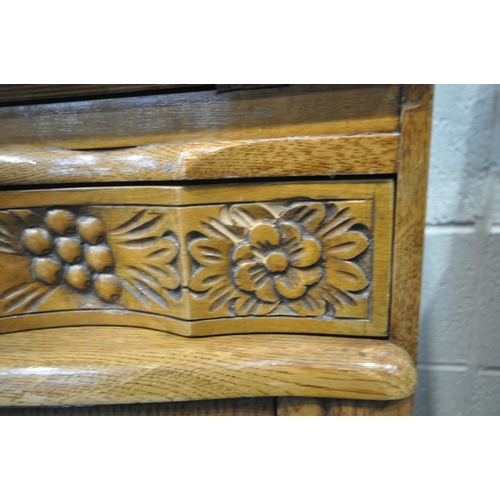 1331 - A 20TH CENTURY OAK BUREAU, the fall front door enclosing a fitted interior, above a single wavy draw... 