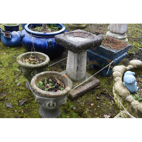 1009 - A WEATHERED COMPOSITE BIRD BATH, height 46cm, along with a pair of small garden urns, diameter 26cm ... 