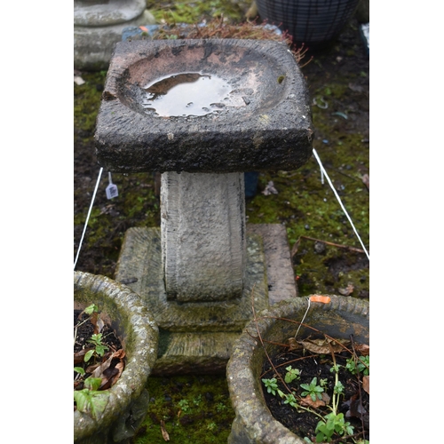 1009 - A WEATHERED COMPOSITE BIRD BATH, height 46cm, along with a pair of small garden urns, diameter 26cm ... 