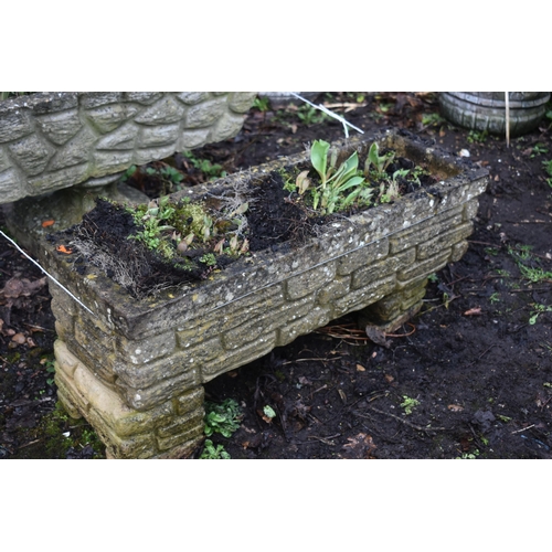 1014 - A NEAR PAIR OF WEATHERED COMPOSITE BRICK EFFECT RECTANGULAR PLANTER, one on a pair of stands, the ot... 