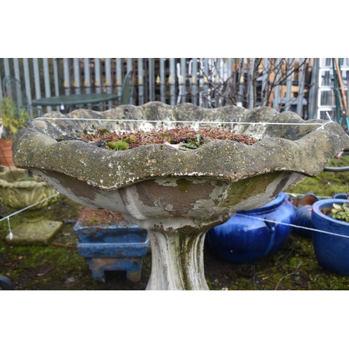 1016 - A LARGE WEATHERED COMPOSITE BIRD BATH, on a spiral base, diameter 89cm x height 64cm (condition repo... 