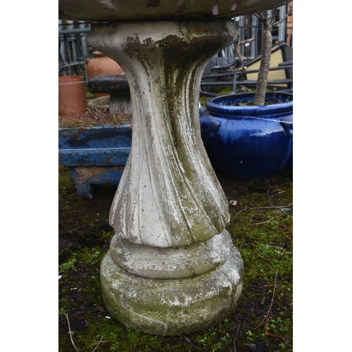 1016 - A LARGE WEATHERED COMPOSITE BIRD BATH, on a spiral base, diameter 89cm x height 64cm (condition repo... 