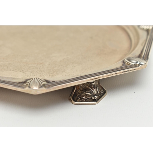 91 - A GEORGE V SILVER WAITER, octagonal form with shell detail, raised on four fish head feet, hallmarke... 