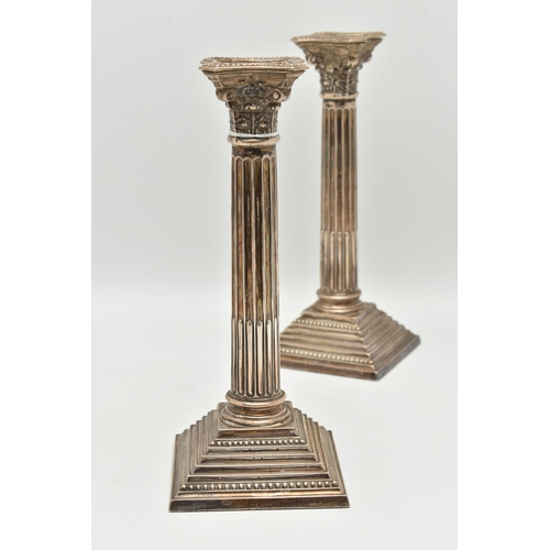 97 - A PAIR OF ELIZABETH II SILVER CORINTHIAN COLUMN CANDLESTICKS, on stepped weighted square bases, hall... 