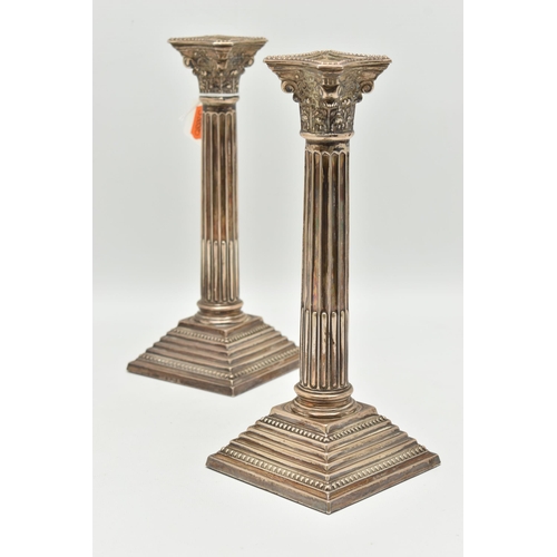 97 - A PAIR OF ELIZABETH II SILVER CORINTHIAN COLUMN CANDLESTICKS, on stepped weighted square bases, hall... 