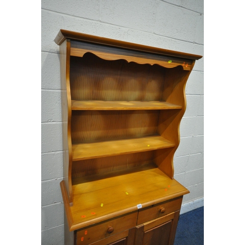 1211 - A MODERN PINE DRESSER, the top two tier plate rack, on a base fitted with two drawers and two cupboa... 