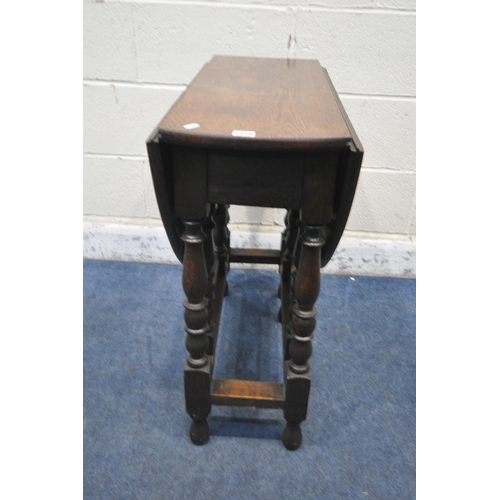 1228 - AN EARLY 20TH CENTURY OAK GATE LEG TABLE, raised on turned supports, united by stretchers, open widt... 