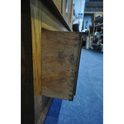 1328 - A 20TH CENTURY OAK WARDROBE, with a single mirror door, above a single drawer, on bun feet, width 12... 