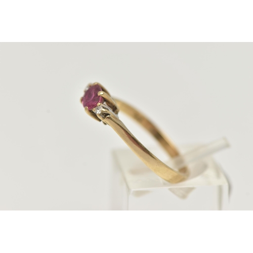 28 - A 9CT GOLD RUBY AND DIAMOND RING, designed as a central oval shape ruby flanked by single cut diamon... 