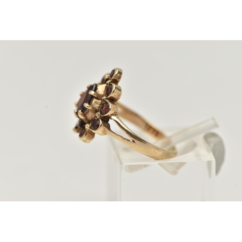 29 - A 9CT GOLD GARNET CLUSTER RING, designed as a central pear shape garnet within a circular cut garnet... 