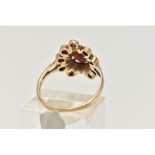 29 - A 9CT GOLD GARNET CLUSTER RING, designed as a central pear shape garnet within a circular cut garnet... 