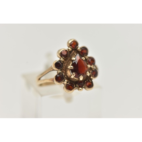 29 - A 9CT GOLD GARNET CLUSTER RING, designed as a central pear shape garnet within a circular cut garnet... 