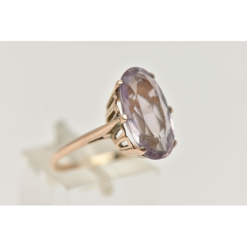 30 - AN AMETHYST RING, the large oval amethyst in a six claw setting, to the plain tapered band, unmarked... 