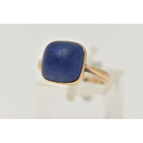 35 - A LAPIS LAZULI RING, designed as a square lapis lazuli cabochon in a collet setting to the plain ban... 