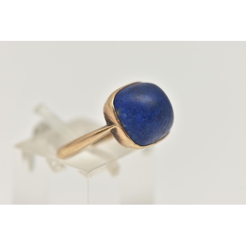 35 - A LAPIS LAZULI RING, designed as a square lapis lazuli cabochon in a collet setting to the plain ban... 