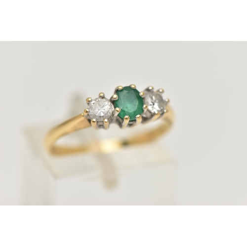 41 - AN 18CT GOLD EMERALD AND DIAMOND RING, the central oval emerald flanked by brilliant cut diamonds, a... 