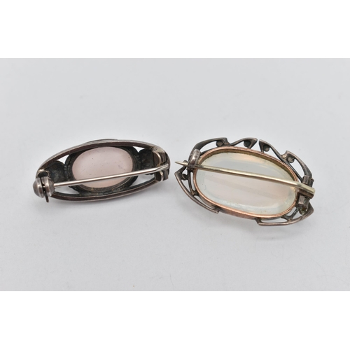 50 - TWO BROOCHES, the first of an oval form, set with an oval cut moonstone cabochon, open work surround... 