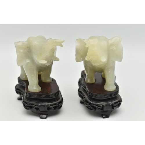 113 - A PAIR OF MODERN CARVED JADE ELEPHANT FIGURINES, each with a molded wooden plinth, approximate heigh... 