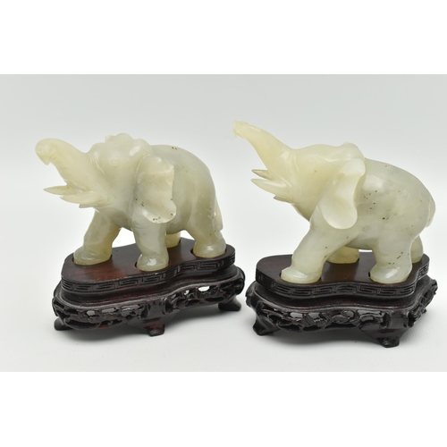 113 - A PAIR OF MODERN CARVED JADE ELEPHANT FIGURINES, each with a molded wooden plinth, approximate heigh... 