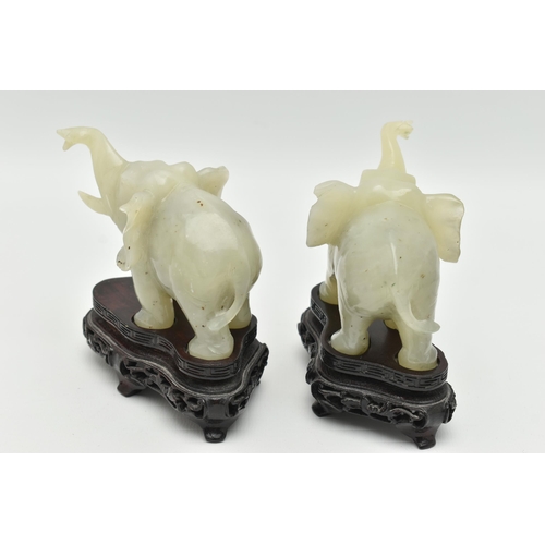 113 - A PAIR OF MODERN CARVED JADE ELEPHANT FIGURINES, each with a molded wooden plinth, approximate heigh... 