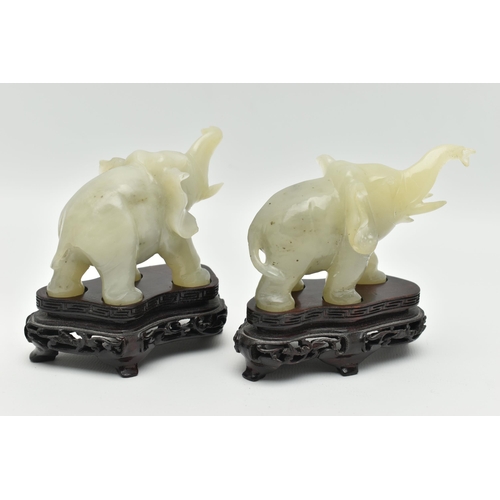 113 - A PAIR OF MODERN CARVED JADE ELEPHANT FIGURINES, each with a molded wooden plinth, approximate heigh... 